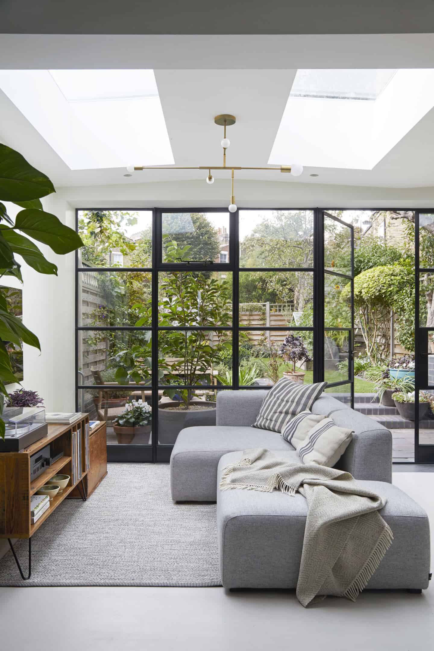 Natural light floods into a living room through flor to ceiling bifold doors that lead straight out to the garden.